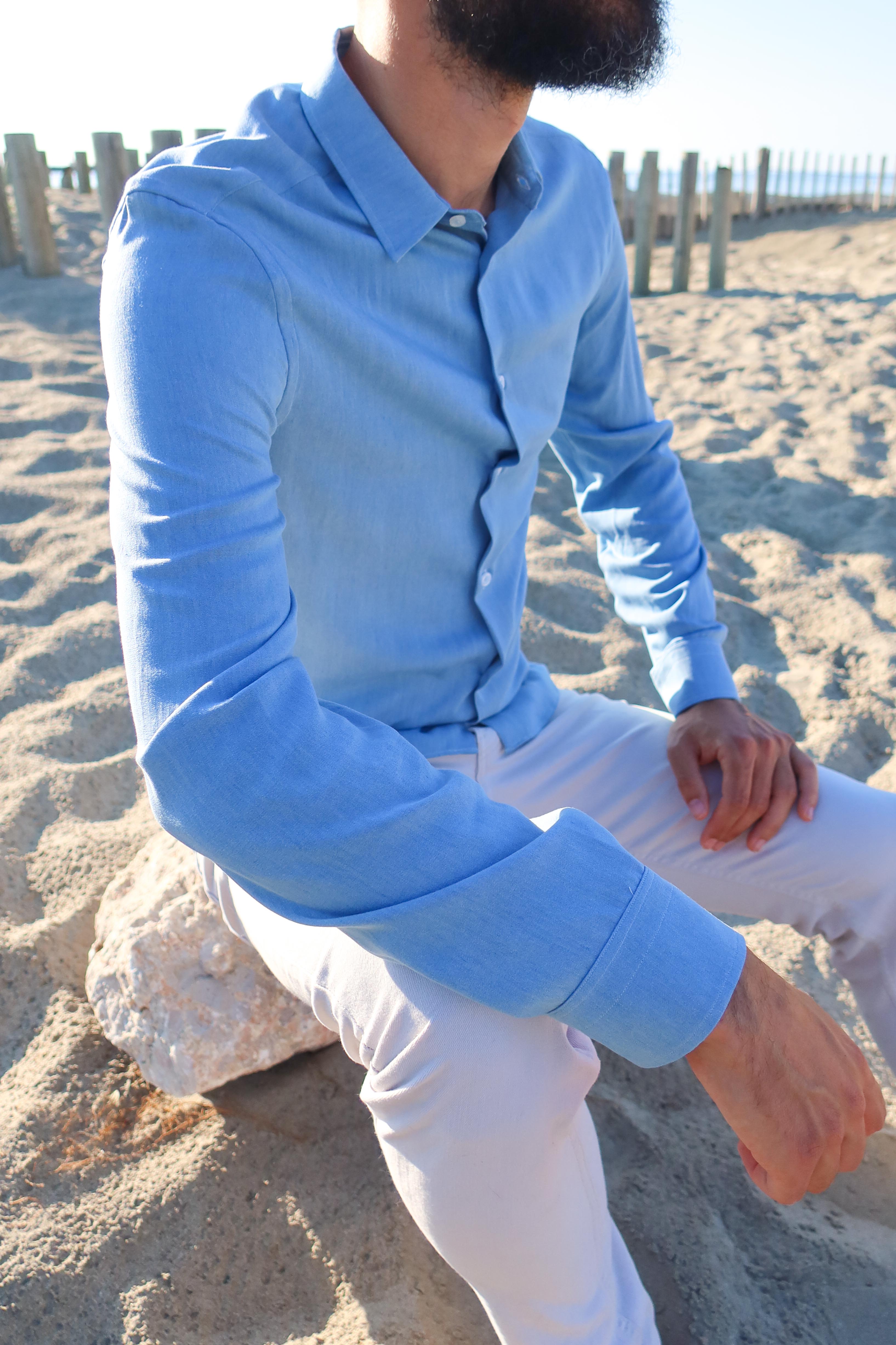 Manche de chemise en tencel en denim bleu clair fabriqué en France portée par le mannequin assis